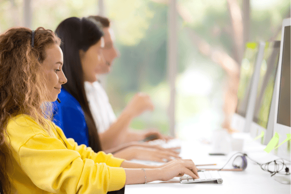 Students using desktop computers in a well-resourced classroom, illustrating the technology and educational tools provided through successful school Medicaid billing.