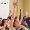 A group of children raising their hands in a Florida classroom where school Medicaid billing supports essential educational services.