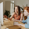 A staff member providing one-on-one support to a student at a computer, showcasing educational services supported by school Medicaid billing in Illinois.